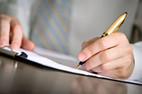 Business Man writing in a book at his desk