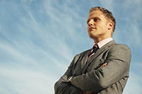 Man standing in front of blue sky, looking confident